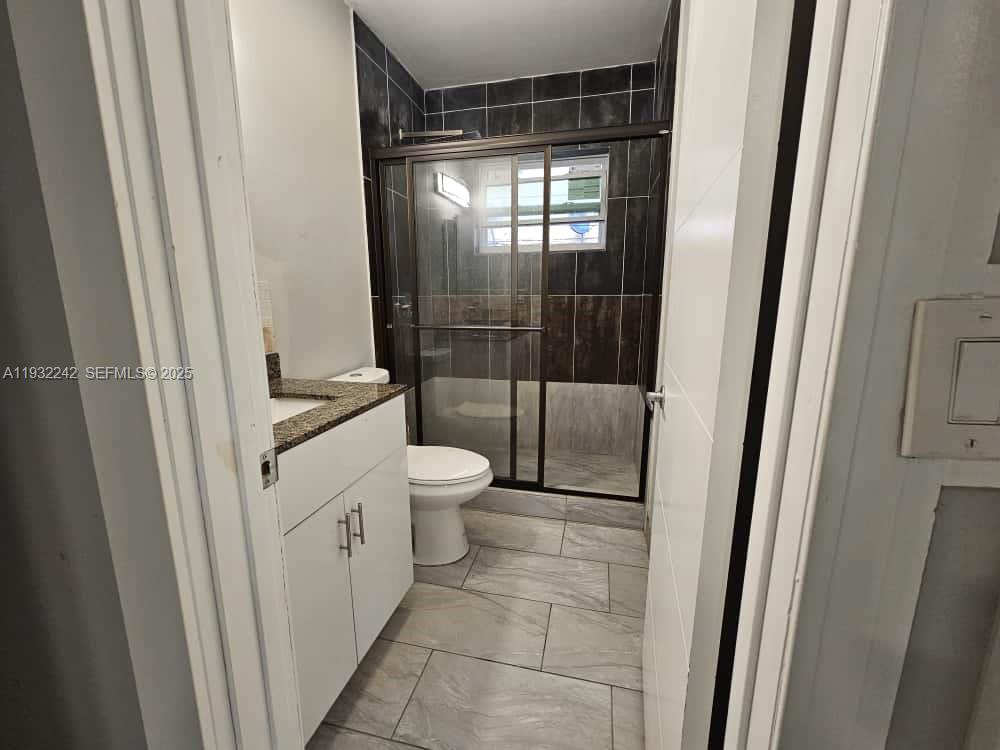 950 Northwest 5th Street, Unit 2 Miami, FL 33128 - Photo 2 of 4 a bathroom with a toilet and a shower