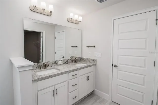a bathroom with a granite countertop sink and a mirror
