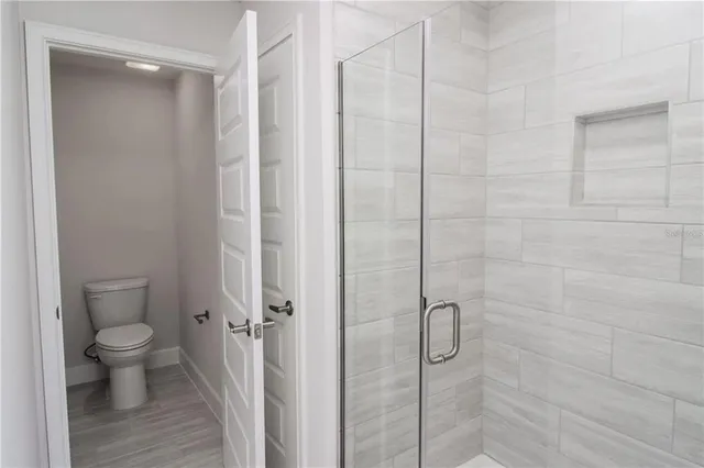 a bathroom with a granite countertop toilet and a shower