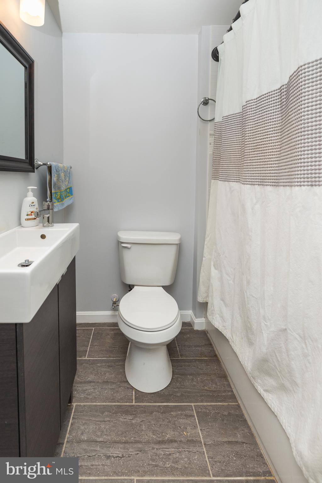 5216 Tramore Road Baltimore, MD 21214 - Photo 16 of 39 a bathroom with a toilet sink and mirror