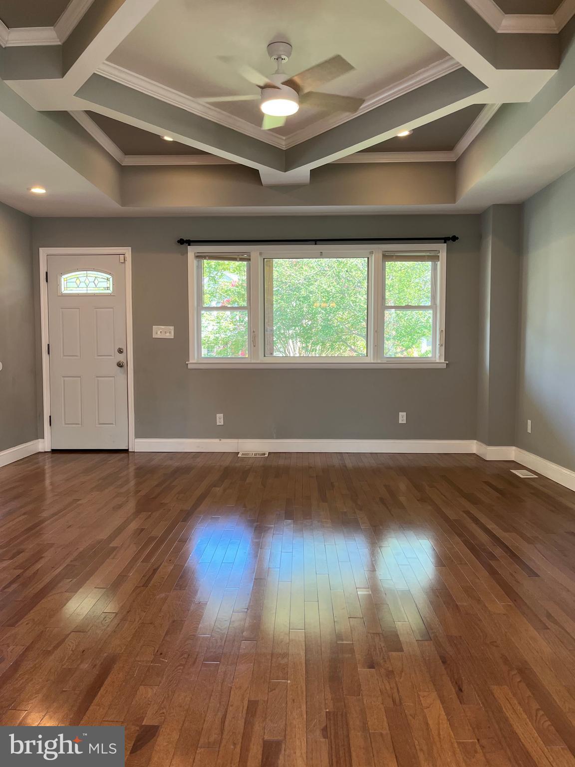 5216 Tramore Road Baltimore, MD 21214 - Photo 4 of 39 an empty room with wooden floor and windows