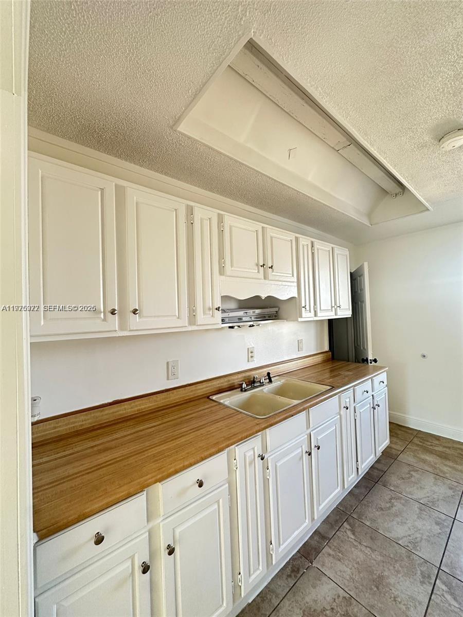 720 Southwest 7th Avenue, Unit 2 Hallandale Beach, FL 33009 - Photo 1 of 7 a kitchen with stainless steel appliances granite countertop a sink and cabinets with wooden floor