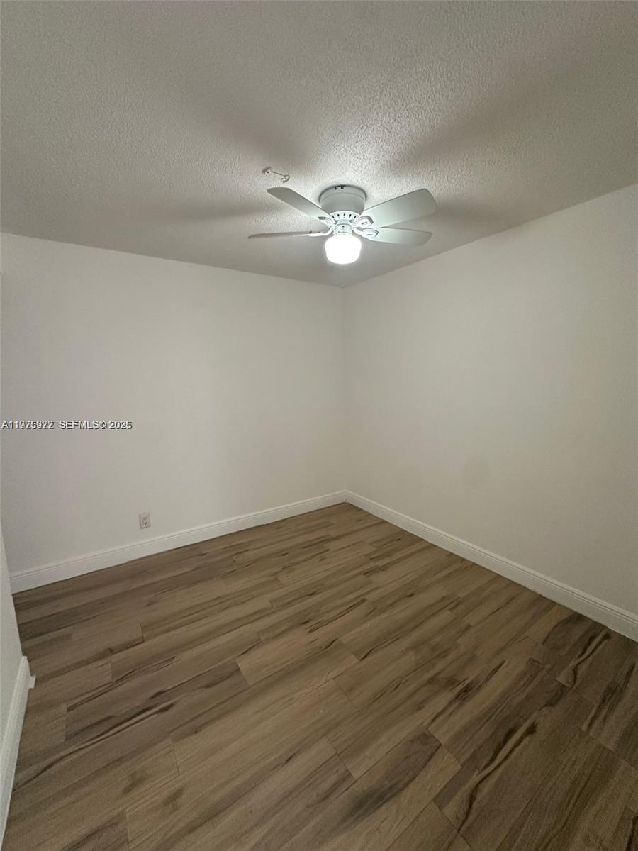 720 Southwest 7th Avenue, Unit 2 Hallandale Beach, FL 33009 - Photo 2 of 7 a view of empty room with wooden floor and ceiling fan