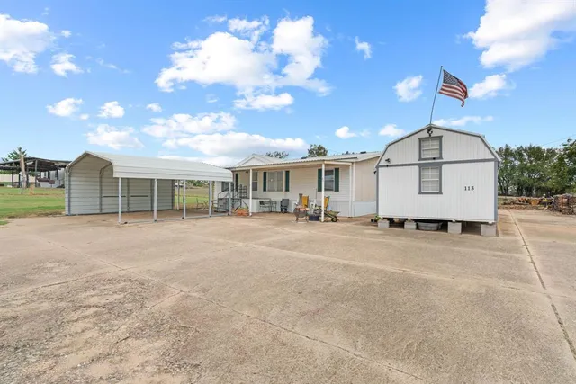 a view of a house with a patio and a yard