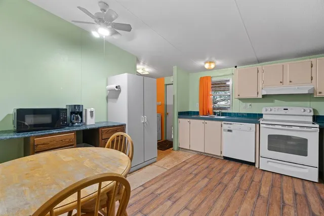 a kitchen with granite countertop a sink stove and refrigerator