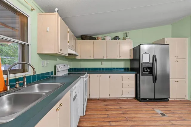 a kitchen with granite countertop white cabinets and stainless steel appliances