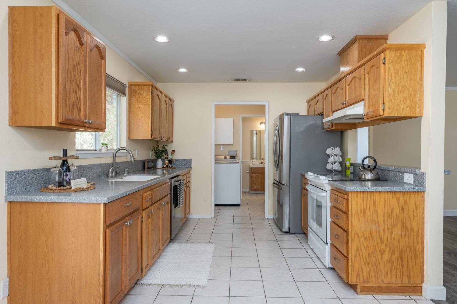 44909 Person Loop North Coarsegold, CA 93614 - Photo 16 of 32 a kitchen with stainless steel appliances granite countertop a refrigerator a sink and a stove
