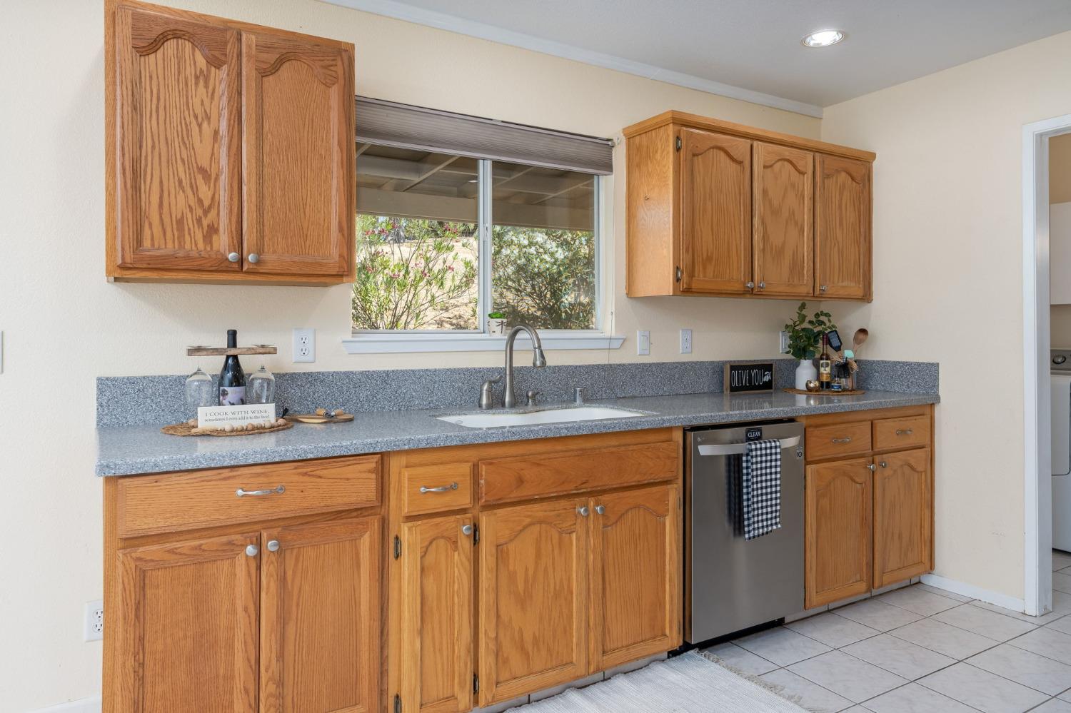 44909 Person Loop North Coarsegold, CA 93614 - Photo 17 of 32 a kitchen with stainless steel appliances granite countertop a sink a cabinets and next to a window