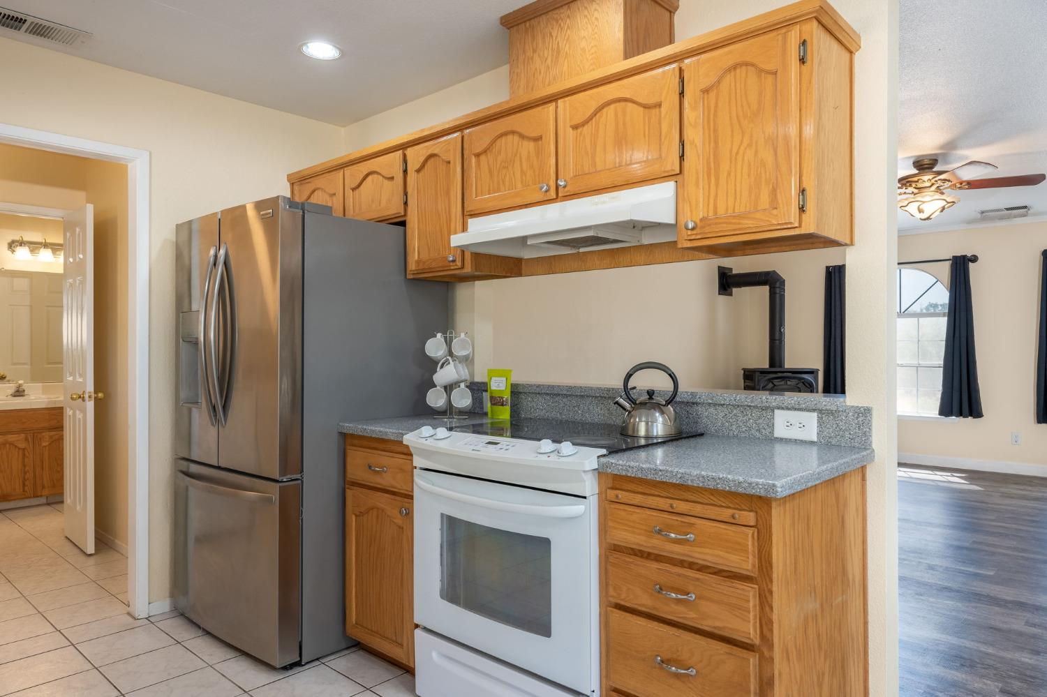 44909 Person Loop North Coarsegold, CA 93614 - Photo 18 of 32 a kitchen with stainless steel appliances granite countertop a refrigerator stove and sink