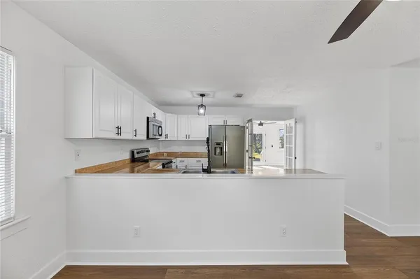 a view of kitchen with stainless steel appliances granite countertop refrigerator sink and stove