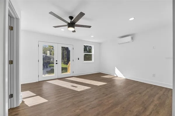 a view of a livingroom with wooden floor and a ceiling fan