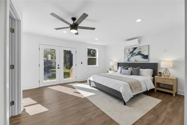 a spacious bedroom with a large bed and a ceiling fan