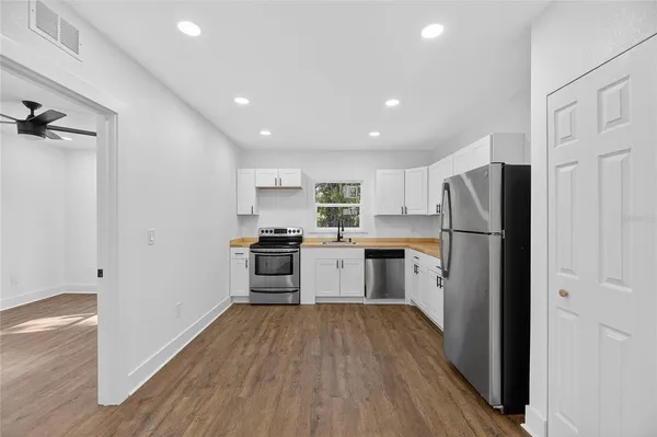 a kitchen with cabinets appliances a sink and a window