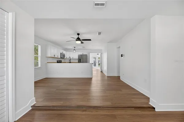 a view of a kitchen with wooden floor and a ceiling fan