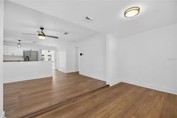 a view of a kitchen with wooden floor and a ceiling fan