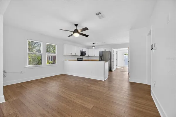 a view of a kitchen with wooden floor and a window