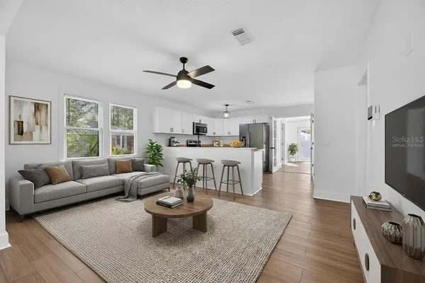 a living room with furniture a flat screen tv and a large window