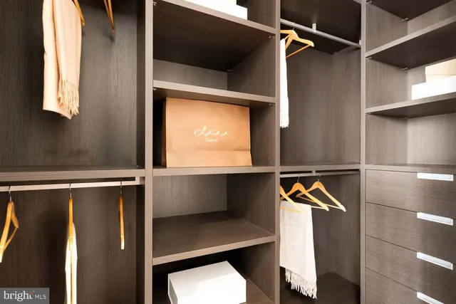 a view of walk in closet with clothes and shoes