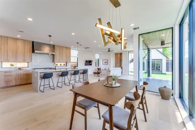 a view of a dining room and livingroom with furniture a rug a painting and a chandelier