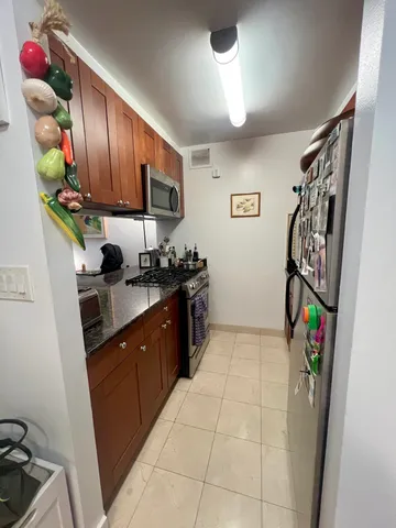 a kitchen with stainless steel appliances granite countertop a refrigerator and a sink