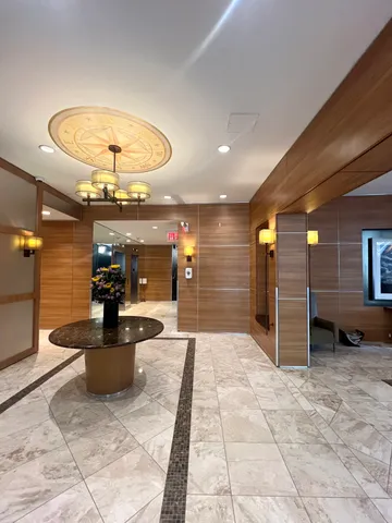 a lobby with furniture and chandelier