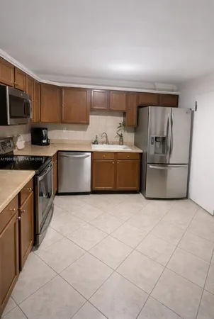 a kitchen with stainless steel appliances granite countertop a stove top oven a sink dishwasher and a refrigerator