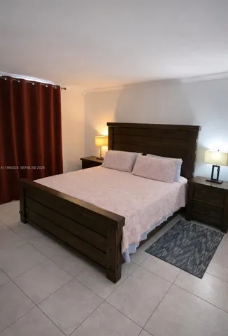 a large bed sitting in a bedroom next to a lamp