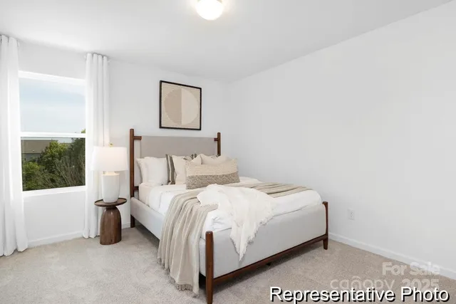 a large bed sitting in a bedroom next to a window