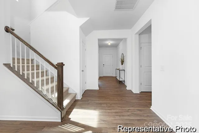 a view of a hallway with wooden floor and staircase