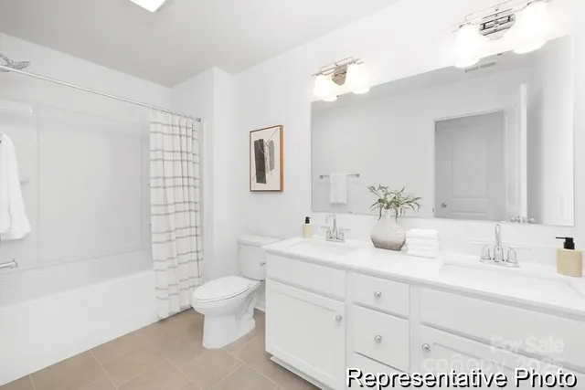 a bathroom with a double vanity sink toilet mirror and shower
