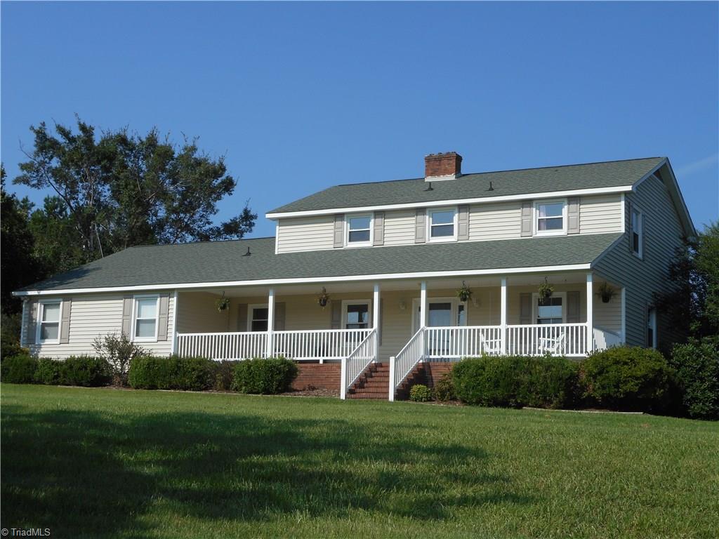 6346 Company Mill Road Climax, NC 27233 - Photo 11 of 30 In this front / right side view you start to get an idea of how the home was designed and built. You have the two car garage on the left, the awesome front porch where you can sit out and relax after a busy day. Enjoy the peace and quiet as you relax in a comfortable chair, sipping on a cool beverage and enjoying some special company.