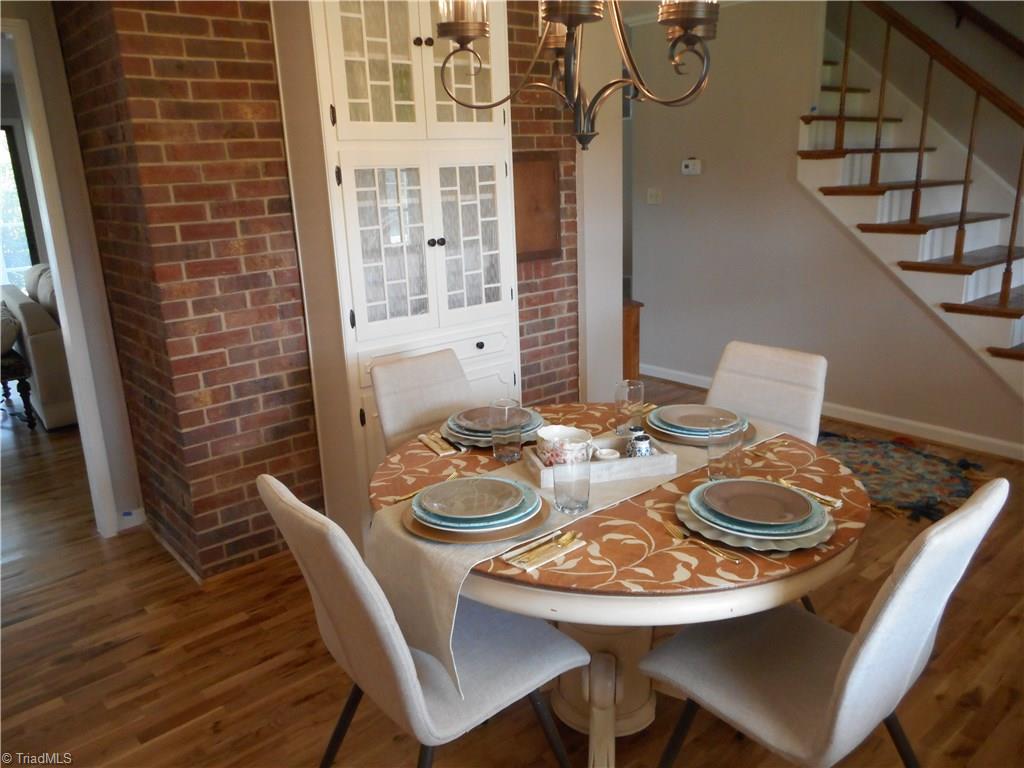 6346 Company Mill Road Climax, NC 27233 - Photo 16 of 30 In this view from the dining room we can see that nice engineered wood flooring, the open door way to the kitchen and den, the brick is from the fireplace in the den and to the right is the staircase and then the master bedroom.