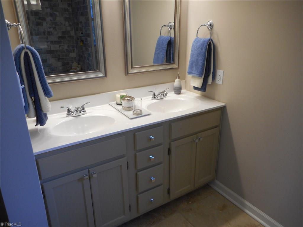 6346 Company Mill Road Climax, NC 27233 - Photo 22 of 30 In this view we are in the master bathroom. Here we can see the double vanity and sink, the new fixtures, the fresh new paint and the tile flooring for easy cleaning.