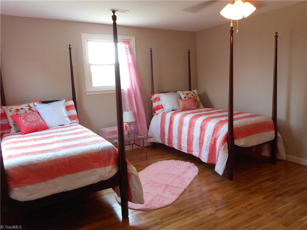 6346 Company Mill Road Climax, NC 27233 - Photo 23 of 30 In this view we are in bedroom two. Here we have engineered wood flooring, fresh new paint, two windows for natural lighting, a ceiling fan with light. Good sized bedroom as you can see. This bedroom also has it's own full bath.