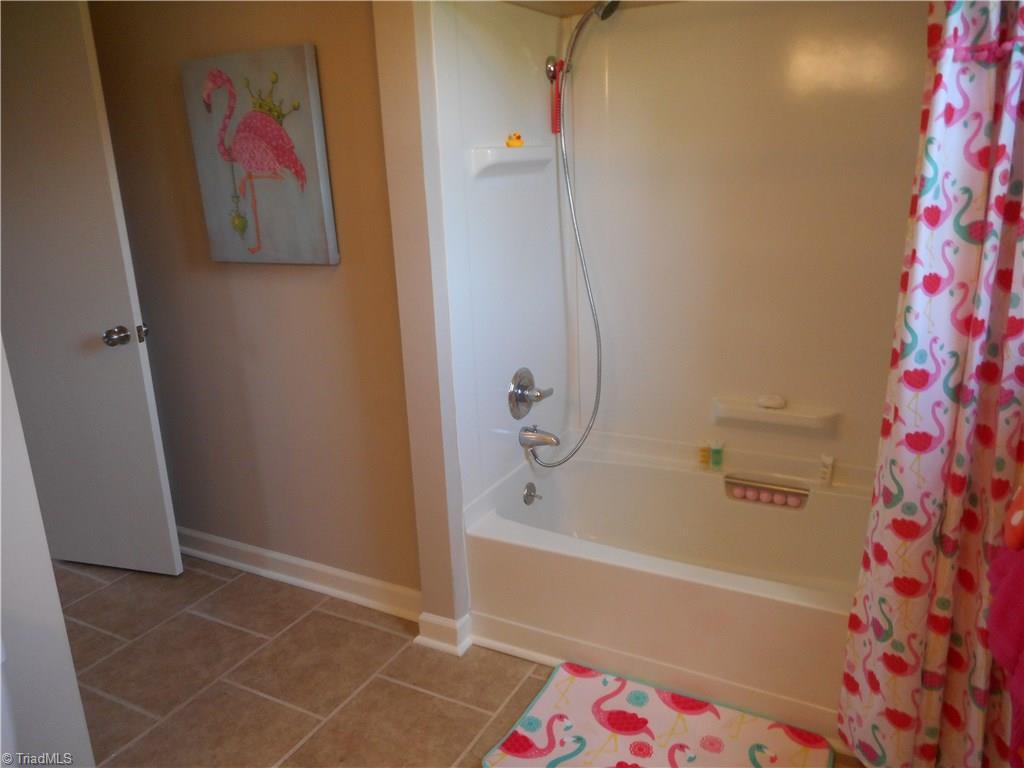 6346 Company Mill Road Climax, NC 27233 - Photo 24 of 30 In this view we are in the full sized bathroom from bedroom two. Here we can see the tiled flooring for easy cleaning, the fresh new paint and the tub / shower unit.