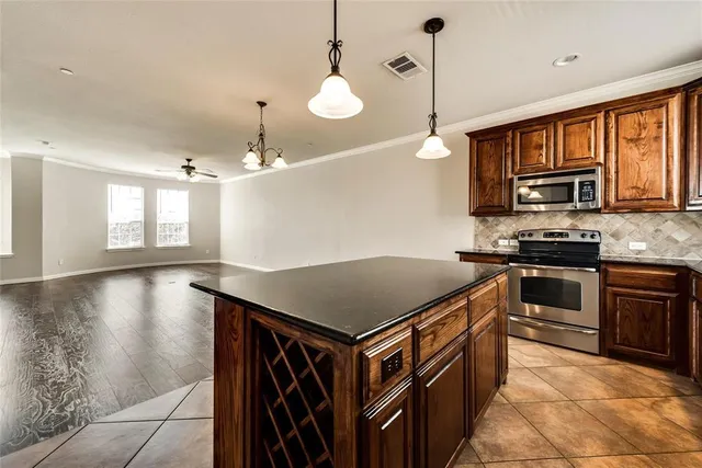 a kitchen with stainless steel appliances granite countertop a stove a sink and a refrigerator