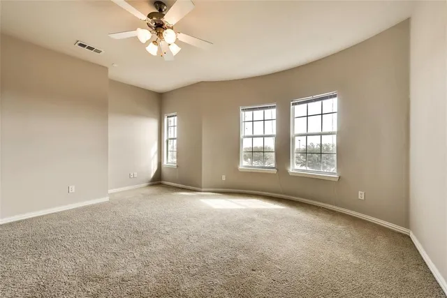 a view of an empty room with a chandelier fan