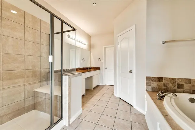 a bathroom with a granite countertop sink mirror and bathtub