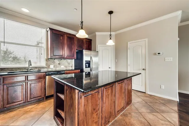 a kitchen with stainless steel appliances granite countertop a sink a stove and a refrigerator