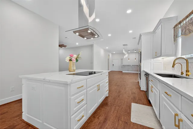 a kitchen that has a lot of cabinets in it and wooden floor