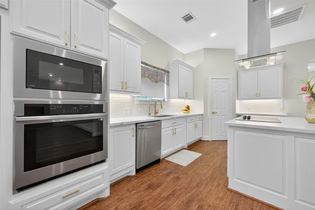 a kitchen with stainless steel appliances kitchen island granite countertop a stove a sink and a microwave