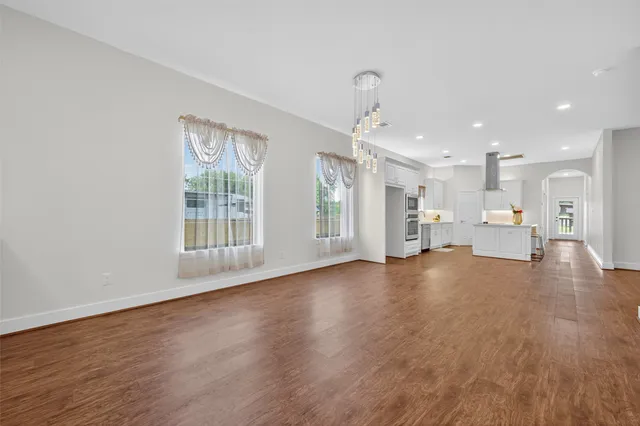 a view of empty room with wooden floor and windows