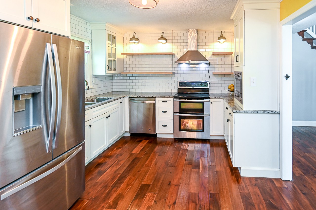 183 Lane Branch Road Fayetteville, TN 37334 - Photo 29 of 48 a kitchen with granite countertop a refrigerator stove and wooden floor
