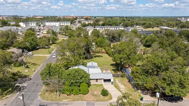 an aerial view of residential houses with outdoor space and lake view