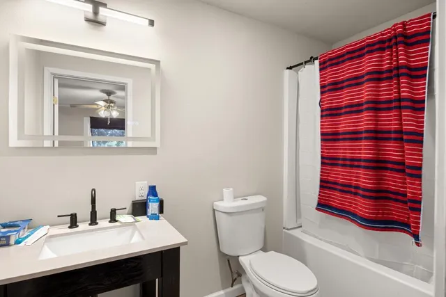 a bathroom with a sink a toilet and shower curtain