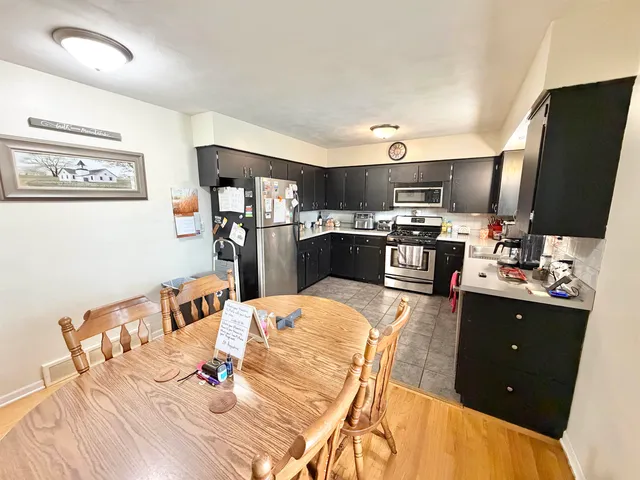 a large kitchen with stainless steel appliances kitchen island granite countertop a refrigerator and a stove top oven