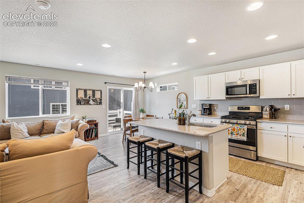 2940 Magic Carpet Loop Colorado Springs, CO 80916 - Photo 7 of 21 a kitchen with stainless steel appliances granite countertop a table and chairs