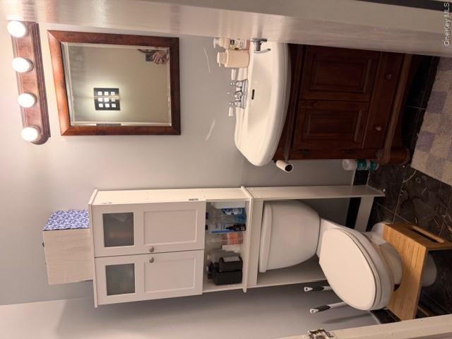 425 Shore Road, Unit 3A Long Beach, NY 11561 - Photo 15 of 17 a bathroom with a sink mirror and toilet