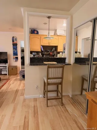 a view of a kitchen with kitchen island granite countertop wooden floor and a sink