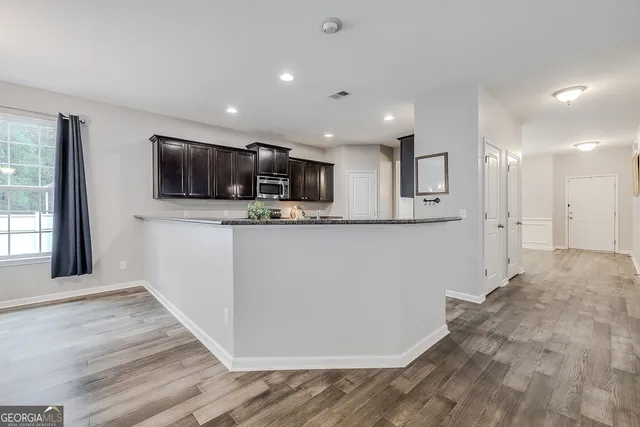 a view of living room kitchen with stainless steel appliances kitchen island